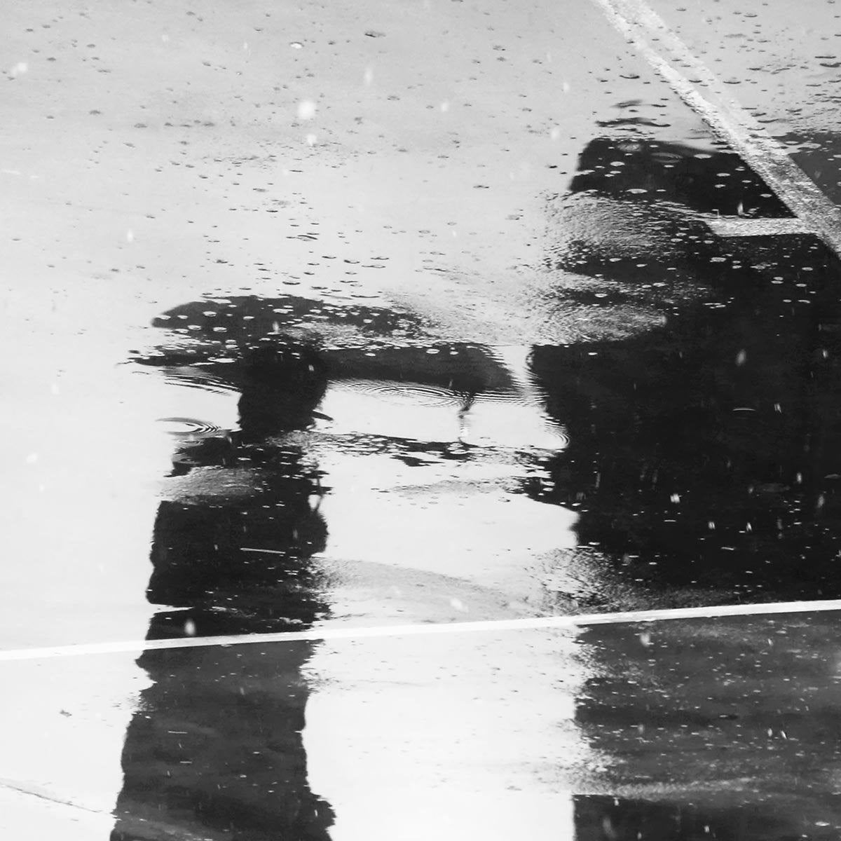 Man's Reflection on a Wet Street